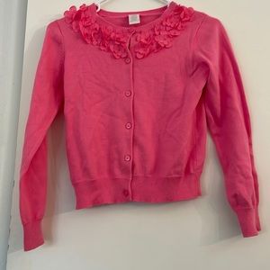 Pink girls cardigan with flower embellishments.